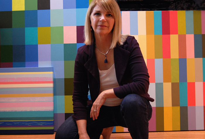 Jill Keller Peters in her studio with her colorful geometric paintings